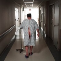 a_patient_in_hospital_gown_walking_-300x300
