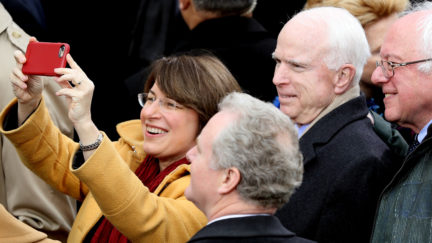 Sen. Amy Klobuchar (D-MN) takes a selfie with Sen. Chris Van Hollen (D-MD), Sen. John McCain (R-AZ) and Sen. Bernie Sanders (D-VT) (R) at U.S. Capitol on January 20, 2017 at Donald J. Trump inauguration ceremony.