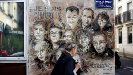 A woman walks past a painting in Paris by French street artist and painter Christian Guemy, known as C215, in tribute to members of Charlie Hebdo newspaper who were killed by jihadist gunmen