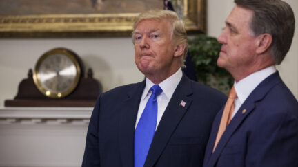 Donald Trump standing with David Perdue