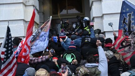 Dozens of pro-Trump supporters storm an entrance to the US Capitol