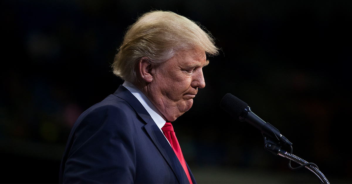 A bejoweled Trump looks down.