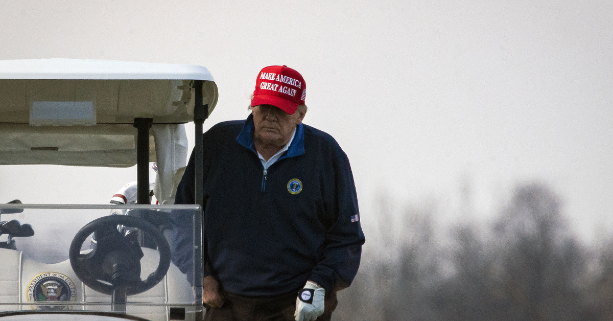 President Donald Trump climbs into golf cart