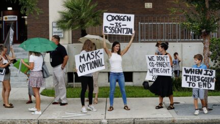 TAMPA, FL - JULY 27: Families protest any potential mask mandates before the Hillsborough County Schools Board meeting held at the district office on July 27, 2021 in Tampa, Florida. The Centers for Disease Control and Prevention recommended those who are vaccinated should wear masks indoors including students returning to school. (Photo by Octavio Jones/Getty Images)