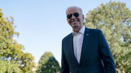 President Joe BIden on White House South Lawn smiling sunglasses