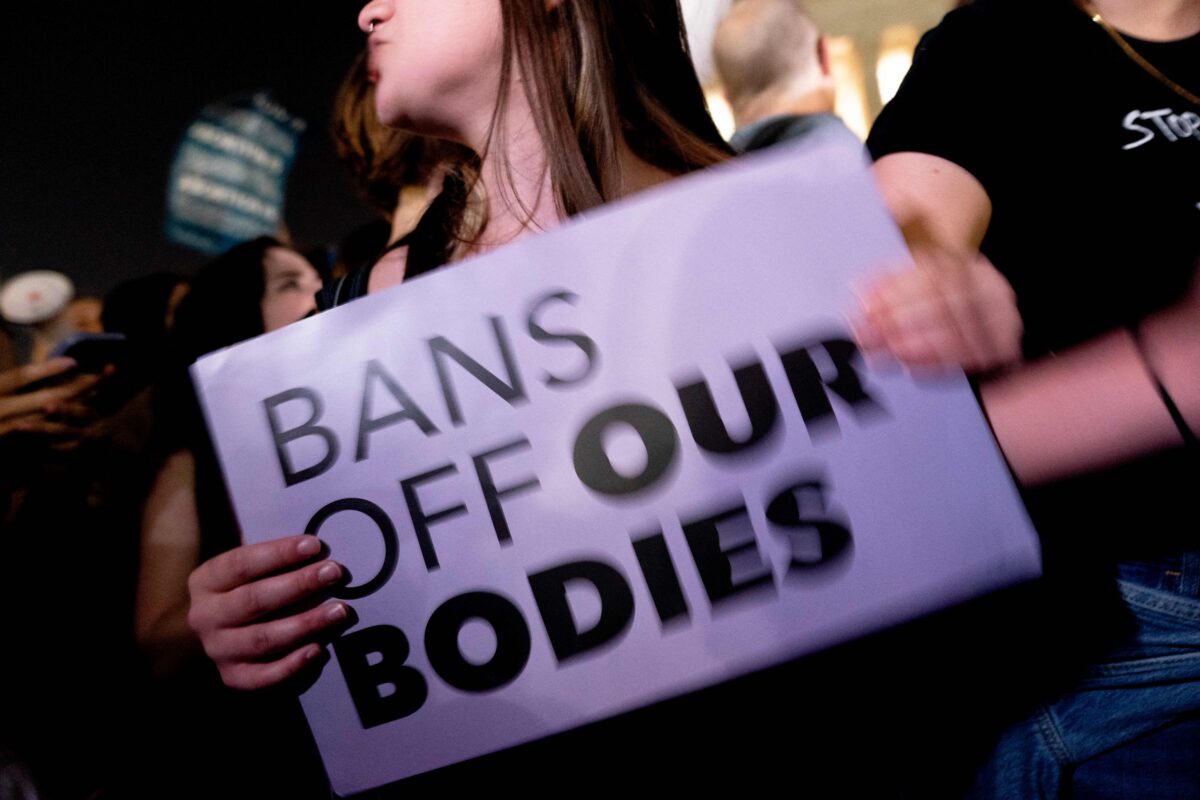 A pro-choice activist holds a sign reading "Bans Off Our Bodies"
