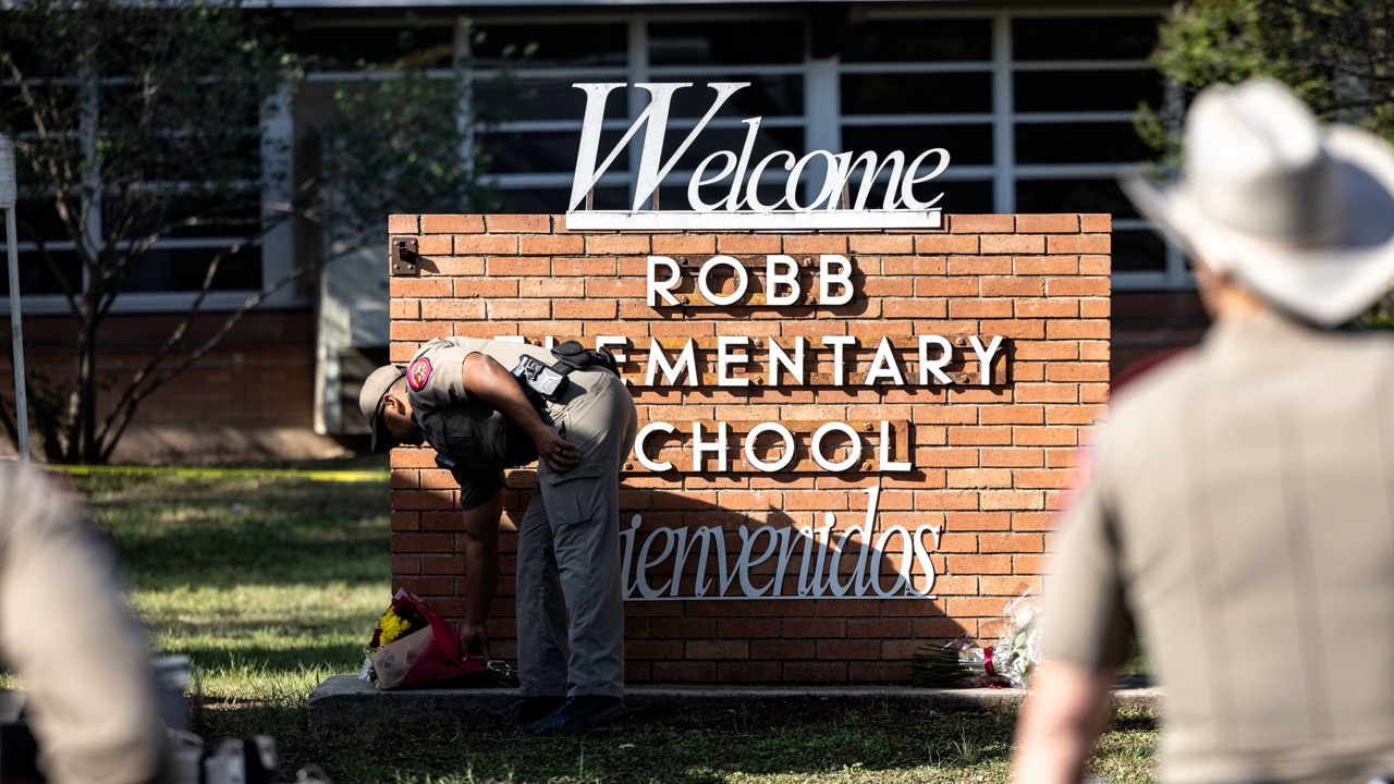 UVALDE, TX - MAY 25: A Texas State Trooper receives flowers for the victims of a mass shooting yesterday at Robb Elementary School where 21 people were killed, including 19 children, on May 25, 2022 in Uvalde, Texas. The shooter, identified as 18-year-old Salvador Ramos, was reportedly killed by law enforcement. (Photo by Jordan Vonderhaar/Getty Images)