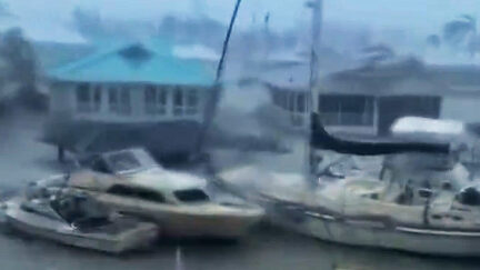 Boats float past houses in Fort Myers Florida - Hurricane Ian 2022