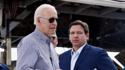 US President Joe Biden arrives to speak in a neighborhood impacted by Hurricane Ian at Fishermans Pass in Fort Myers, Florida, on October 5, 2022 as Florida Governor Ron DeSantis looks on
