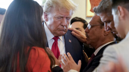 Former President Donald Trump prays with pastor Mario Bramnick, third from right, and others at Versailles restaurant on Tuesday, June 13, 2023, in Miami. Trump appeared in federal court Tuesday on dozens of felony charges accusing him of illegally hoarding classified documents and thwarting the Justice Department's efforts to get the records back.