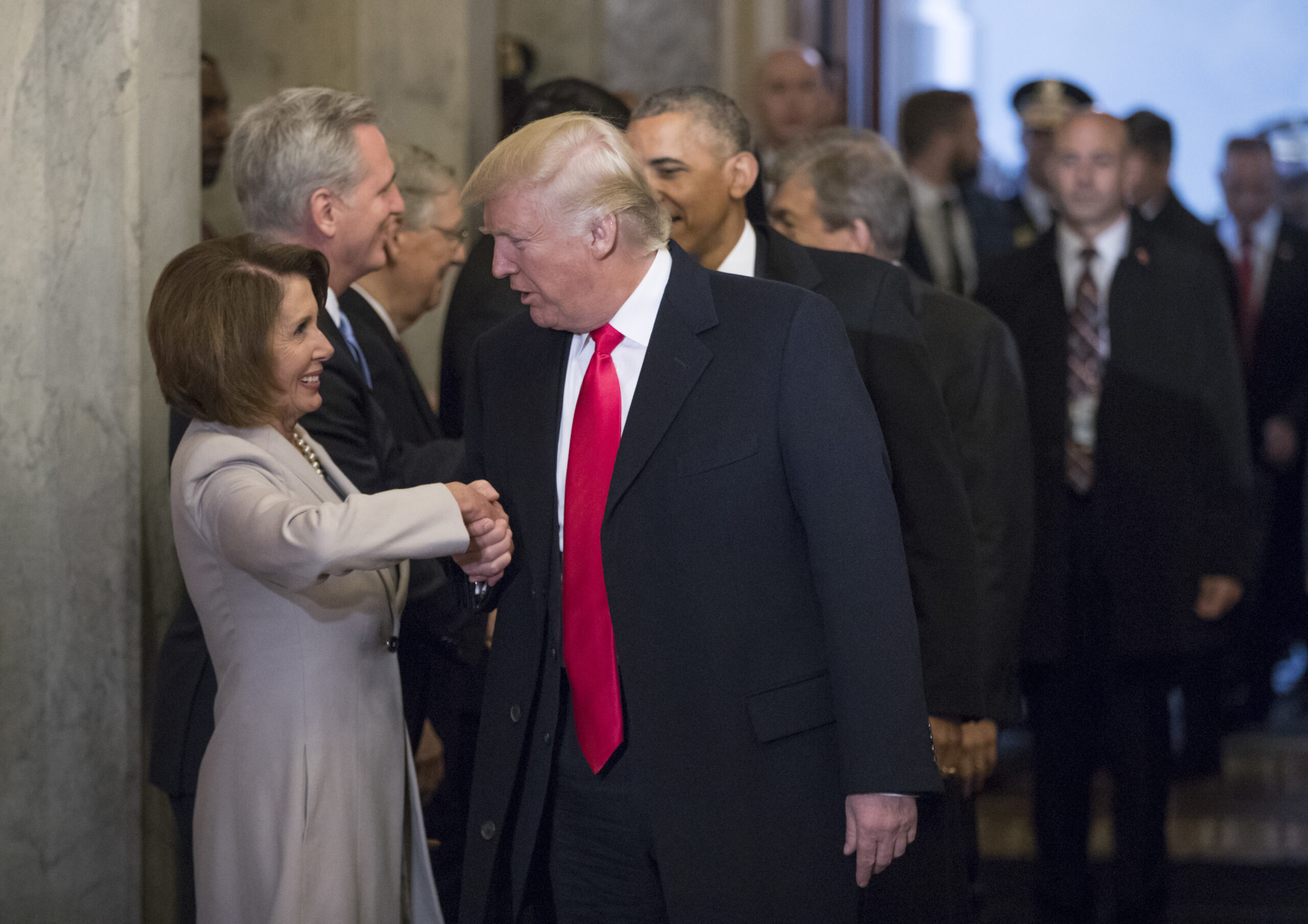 Nancy Pelosi shaking hands with Donald Trump