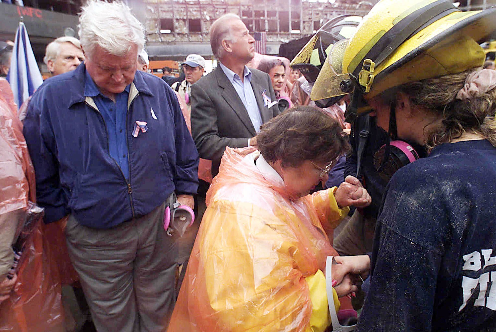 FILE - In this Sept. 20, 2001, file photo Sen. Ted Kennedy, D-Mass., left, and Sen. Joe Biden, center, stand by as Sen. Barbara Mikulski, D-Md., in orange parka, joins in prayer with rescue workers at the site of the World Trade Center in New York. They were part of a delegation of Senators that traveled by train to New York to view the rubble that once was the World Trade Center.