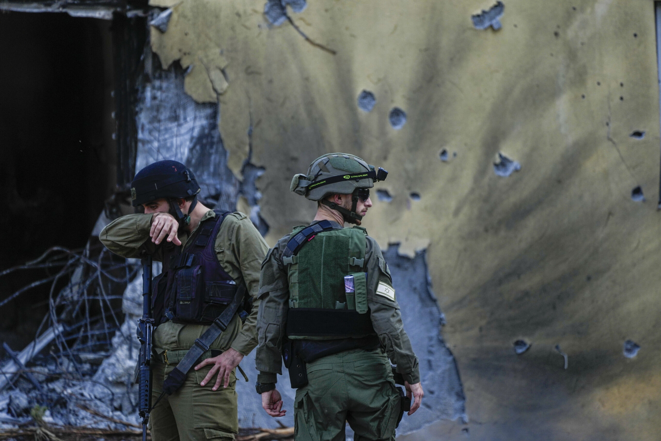 Israeli soldiers walk past houses destroyed by Hamas.