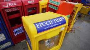 Plastic newspaper racks for The Epoch Times, The Village Voice and other newspapers stand along a Manhattan sidewalk, Wednesday, Nov. 27, 2013 in New York.