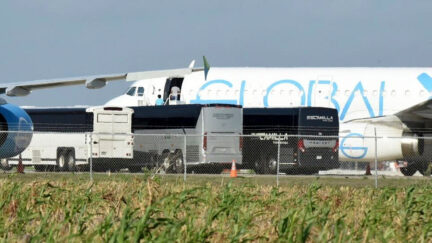 People board plane in Texas on Sunday, Aug. 31 where four charter buses unload as Trump tries to deport dozens of Guatemalan children. - AP