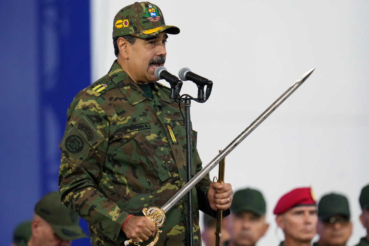 Venezuelan President Nicolas Maduro holds a ceremonial sword during a government-organized civic-military march in Caracas