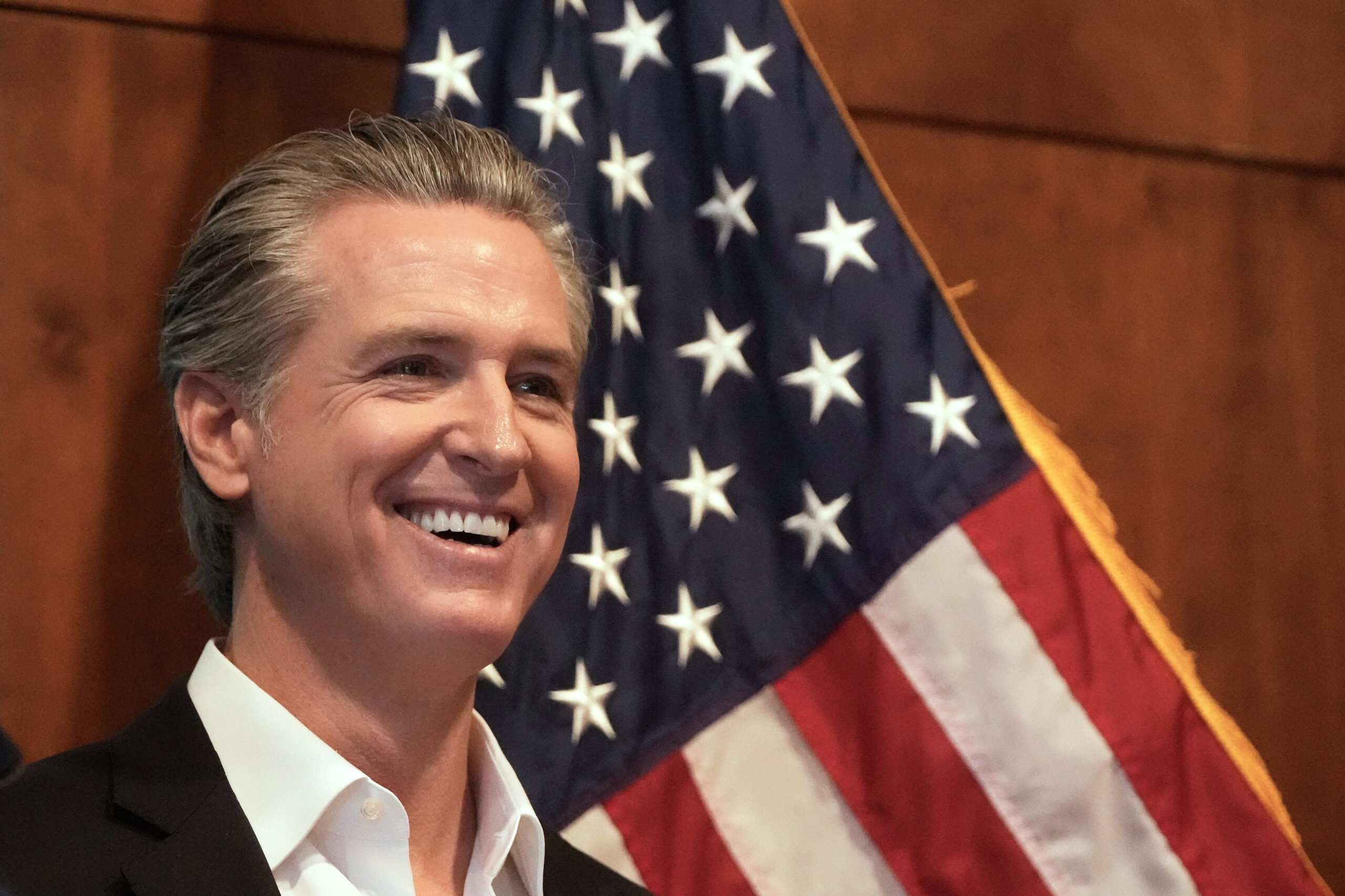 California Gov. Gavin Newsom in front of U.S. Flag