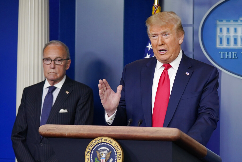President Donald Trump speaks during a news briefing at the White House, Thursday, July 2, 2020, in Washington, as White House chief economic adviser Larry Kudlow looks on.