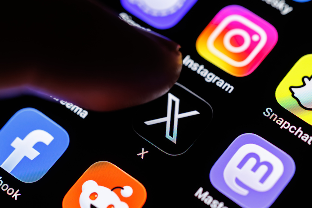 07 March 2026, Bavaria, Munich: The logo of the X app (formerly Twitter) can be seen on the display of a smartphone in Munich (Bavaria, Germany) on March 7, 2026, while a finger taps on the application icon. X is a social media network that was developed as a microblogging platform by Twitter Inc. The service was acquired in 2022 by X Corp, a company majority-controlled by Musk. (pointing finger, icon, symbol image, symbol photo, illustration, symbolic photo, illustrative photo, theme image, general image, theme photo) Photo by: Matthias Balk/picture-alliance/dpa/AP Images