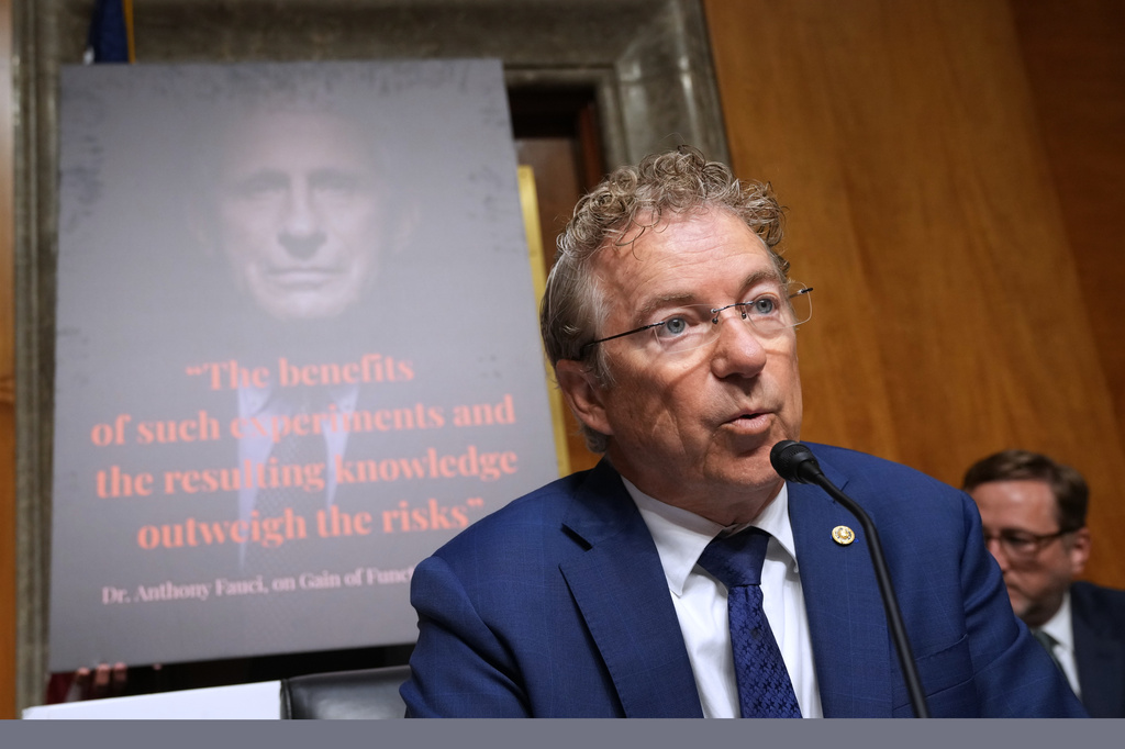 Rand Paul with image of anthony fauci on a screen behind him