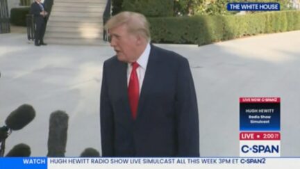 trump talking to press with microphones in the foreground
